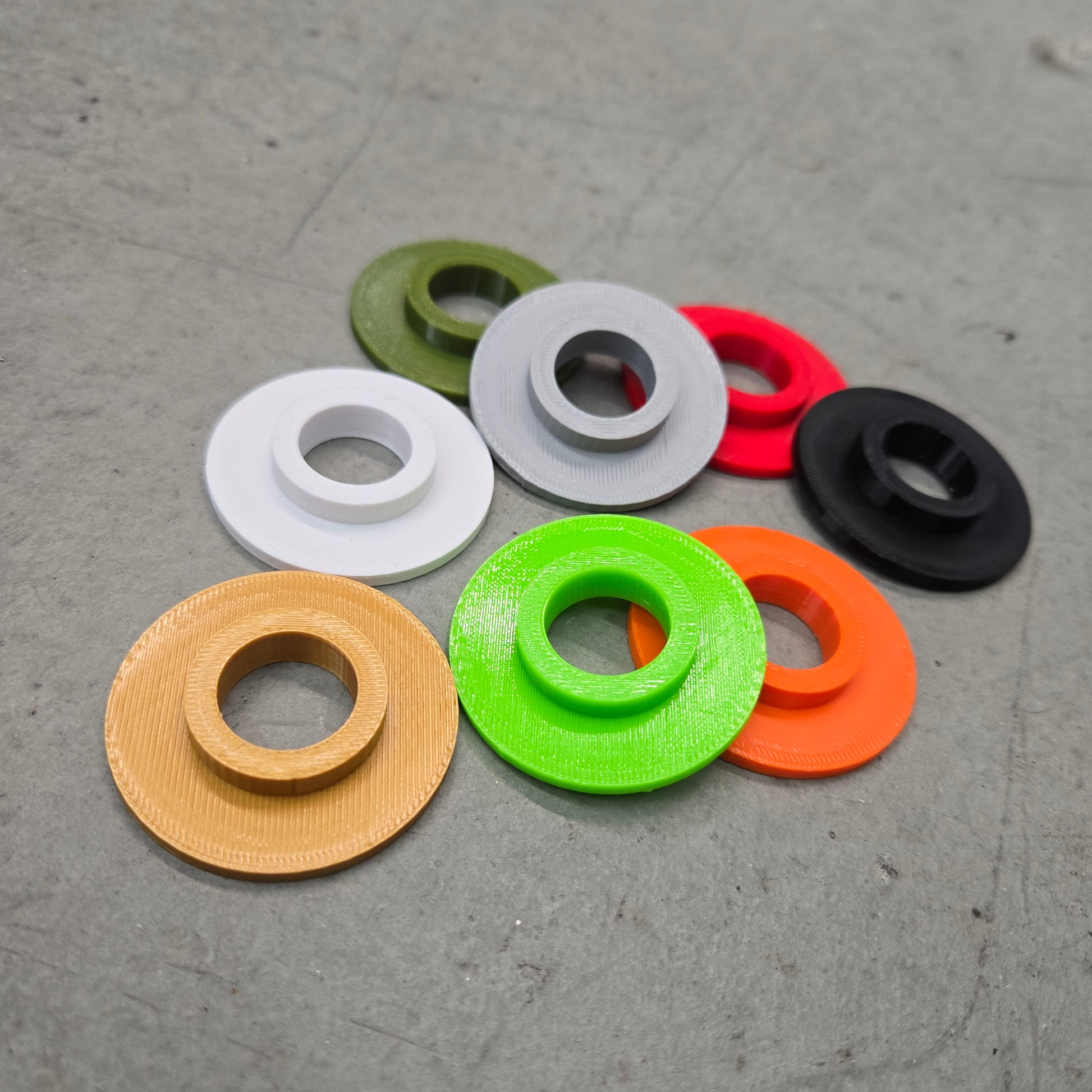 Darko Lifting Single-Hole Adapter plate converting 5/8-inch rack holes to 1-inch, shown in multiple color options