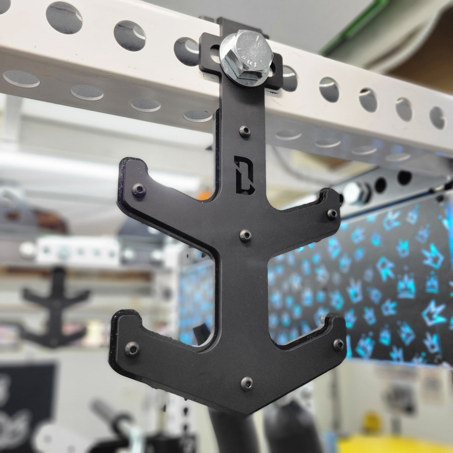 A black barbell anchor mounted on a power rack, designed to store multiple barbells.